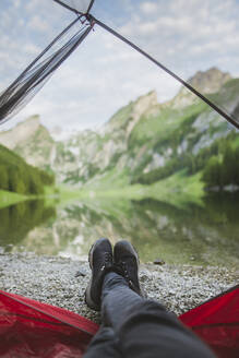 Woman's feet sticking out of tent by Seealpsee lake in Appenzell Alps, Switzerland - TETF00063