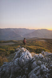 Man on rock by mountains at sunset - TETF00068