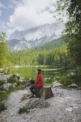 Germany, Bavaria, Eibsee, Woman sitting by Frillensee lake - TETF00079