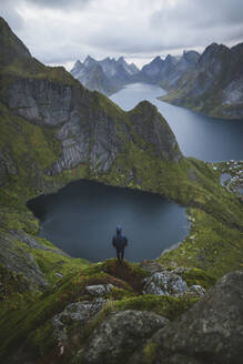 Norwegen, Lofoten-Inseln, Reine, Mann betrachtet Aussicht vom Berg Reinebringen - TETF00090