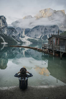 Italien, Frau sitzend am Pragser Wildsee in den Dolomiten - TETF00106