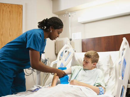 Krankenschwester prüft Blutdruck bei einem Jungen (10-11) - TETF00113