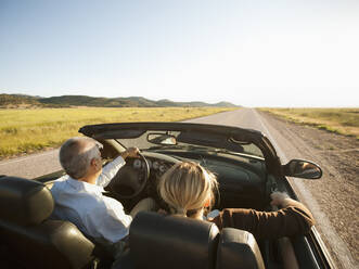 USA, Utah, Kanosh, Mad-adult couple driving through desert plains in convertible car - TETF00117