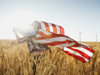 Mädchen (12-13) mit amerikanischer Flagge in einem Weizenfeld - TETF00118