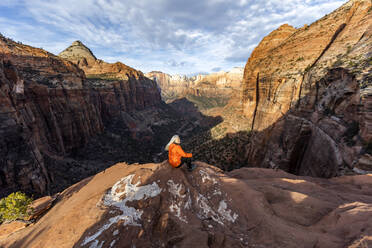 Frau sitzt auf einer Klippe im Zion National Park in Utah, USA - TETF00174