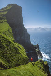 Dänemark, Färöer Inseln, Klaksvik, Trollanes, Frau steht auf Klippe und schaut aufs Meer - TETF00183