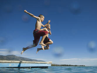 Brothers jumping off dock into lake, Utah, United States - TETF00225