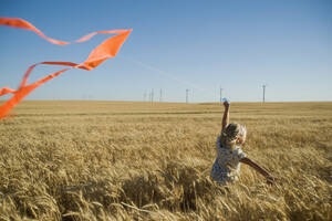 Mädchen läuft mit Drachen auf Windpark - TETF00231