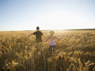 Children running through tall wheat field - TETF00233