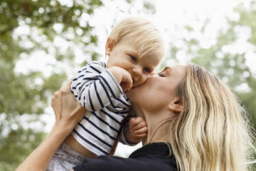 Mutter küsst kleines Mädchen auf die Wange, im Freien - TETF00344