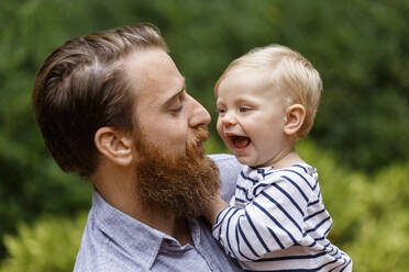 Portrait of father and baby girl, outdoors, laughing - TETF00345