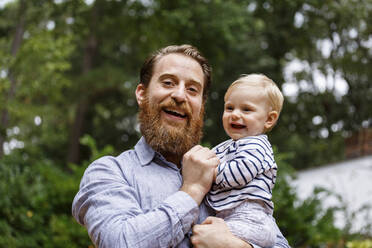 Portrait of father and baby girl, outdoors, laughing - TETF00346