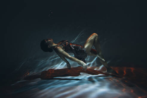 Junge Frau in Seidenkleid schwimmt unter Wasser im Meer - SIF00043