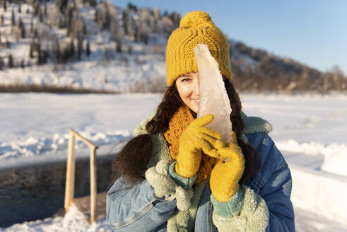 Frau bedeckt Gesicht mit Eis im Winterwald - VBUF00031