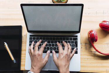 Businesswoman typing on laptop working in coffee shop - PNAF03330