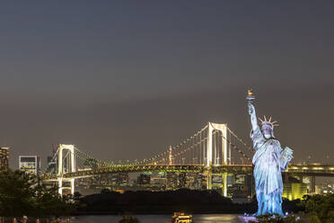 Japan, Region Kanto, Tokio, Nachbildung der Freiheitsstatue und beleuchtete Regenbogenbrücke bei Nacht - FOF12916