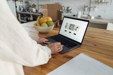 Unternehmerin, die ihren Blog web page der Keramik auf dem Laptop im Geschäft untersucht - VPIF05558
