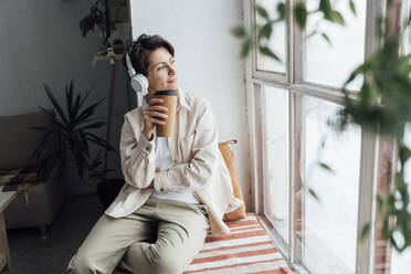 Thoughtful woman having coffee by window - VPIF05581