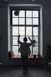 Woman dancing in front of window - VPIF05592