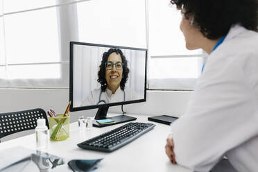 Arzt im Videogespräch mit Kollege über Desktop-PC in der Klinik - XLGF02759