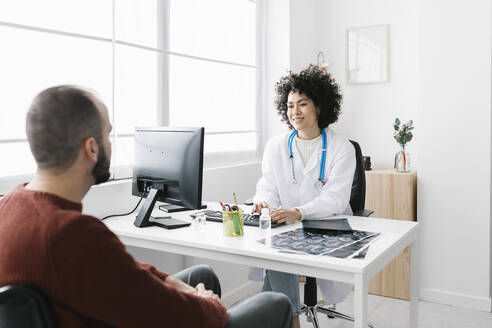 Arzt im Gespräch mit einem Patienten in einer medizinischen Klinik - XLGF02775