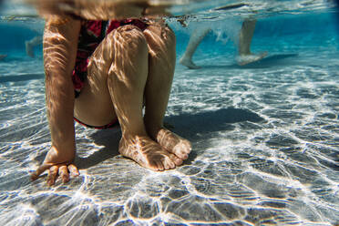 Mädchenbeine unter Wasser am Pool an einem heißen Sommertag - CAVF95370