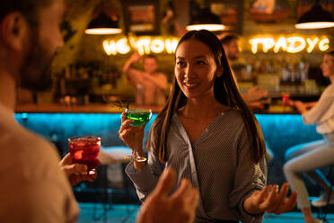 Fröhliche asiatische Frau im Gespräch in einer Bar - CAVF95428