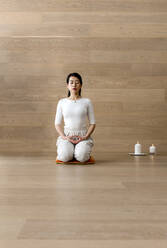 Asian woman practicing yoga, sitting in seiza pose, vajrasana exercise - CAVF95471