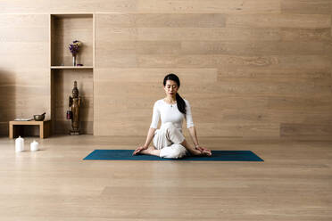 Asian woman practice yoga Gomukhasana or Cow Face pose to meditation - CAVF95479