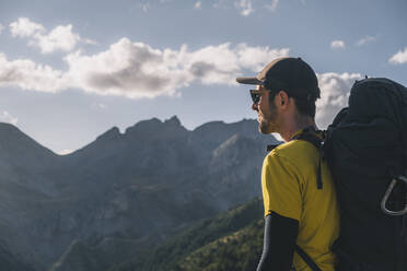 Happy man wearing a backpack in the mountains. - CAVF95619