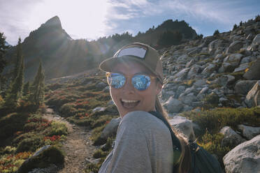 Nahaufnahme von glücklichen weiblichen Wanderer mit Sonnenbrille auf Blick auf Kamera - CAVF95631