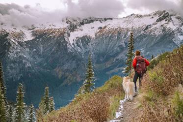 Wanderin und Hund auf einem Wanderweg in den North Cascade Mountains - CAVF95640