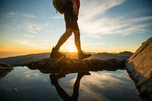 Lower half of backpacker walking on summit ridge. - CAVF95644