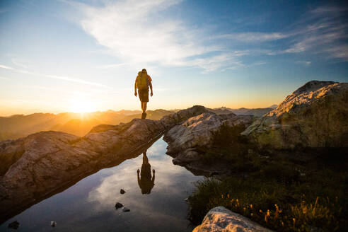 Reflected view of backpacker hiking on mountain rige. - CAVF95645