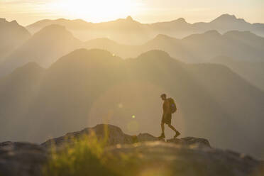 Side view of hiker walking on rocky alpine ridge, Vancouver B.C. - CAVF95646