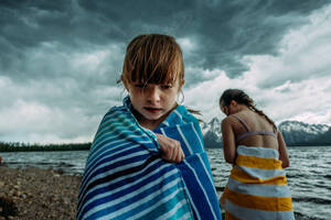 Junge Mädchen in Handtücher eingewickelt an einem Bergsee - CAVF95649