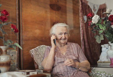 Portrait of elderly lady in her home while telephoning - CAVF95685