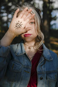 Junge Frau zeigt Augenzeichen-Tätowierung auf ihrer Hand - ORF00007