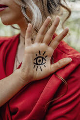 Junge Frau zeigt Augenzeichen-Tätowierung auf ihrer Hand - ORF00013