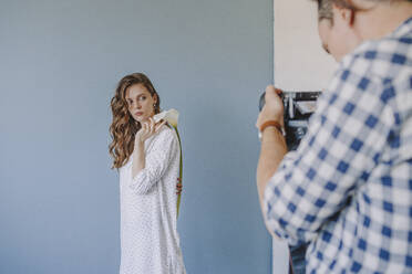 Photographer taking woman's picture standing by wall - ORF00016