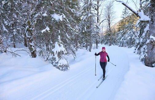 Ältere Frau mit Skistock beim Skifahren im Schnee im Urlaub - MRF02505