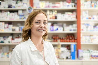 Smiling female pharmacist at pharmacy store - ZEDF04466