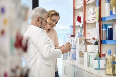 Apothekerin, die einem Kunden in einer Apotheke ein Medikament gibt - ZEDF04472