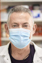 Pharmacist wearing protective face mask at pharmacy store - ZEDF04487