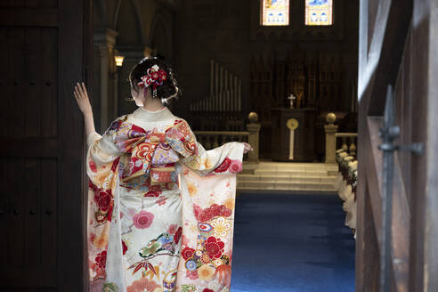 A woman spreading the furisode in a chapel - CAVF95769