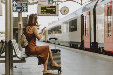 Tourist woman sitting in Antwerp train station - CAVF95770