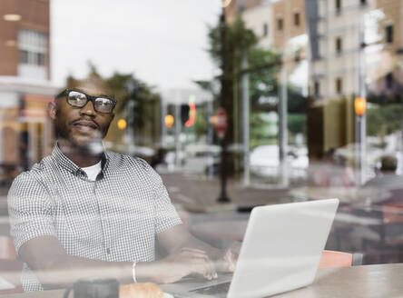 Black man using laptop in coffee shop - TETF00358