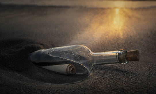 Glasflasche mit Nachricht am Strand bei Sonnenuntergang - TETF00360