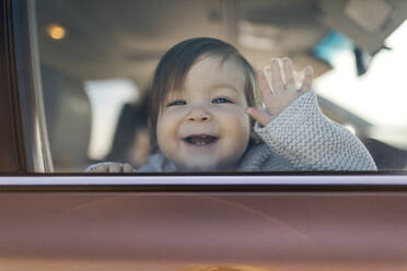 Lächelndes kleines Mädchen hinter dem Autofenster - TETF00403