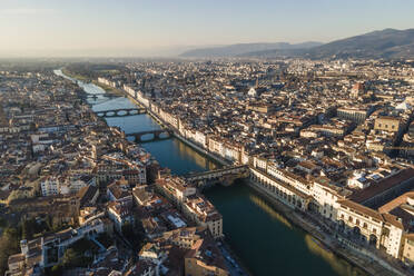 Aerial view of Florence skyline along Arno river at sunset with Ponte Vecchio bridge in foreground, Florence, Tuscany, Italy. - AAEF14166